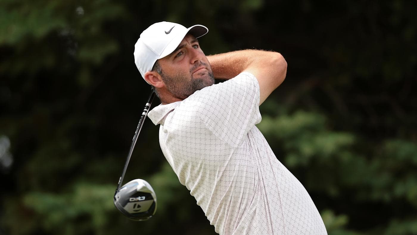Scottie Scheffler in a white cap and black shirt, fist raised after a putt at the 2026 3M Open.