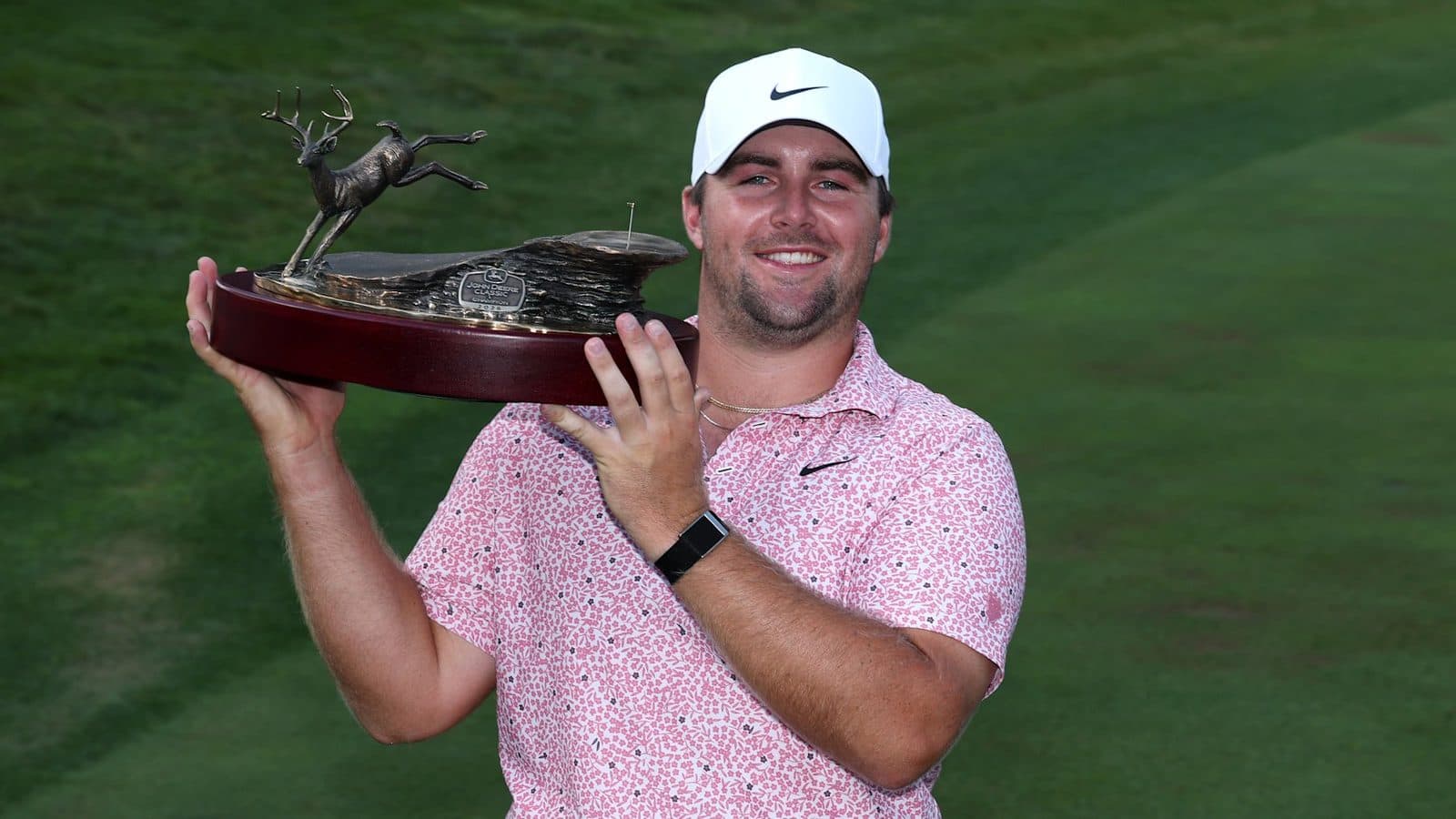 Chris Gotterup holding the John Deere Classic trophy.