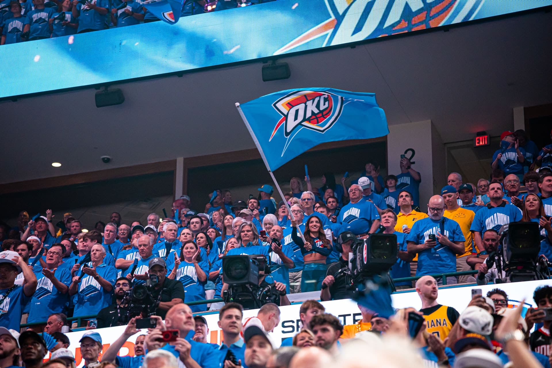 Shai Gilgeous-Alexander in a white Oklahoma City Thunder jersey holding the Larry O'Brien Trophy after Game 7 of the 2025 NBA Finals.