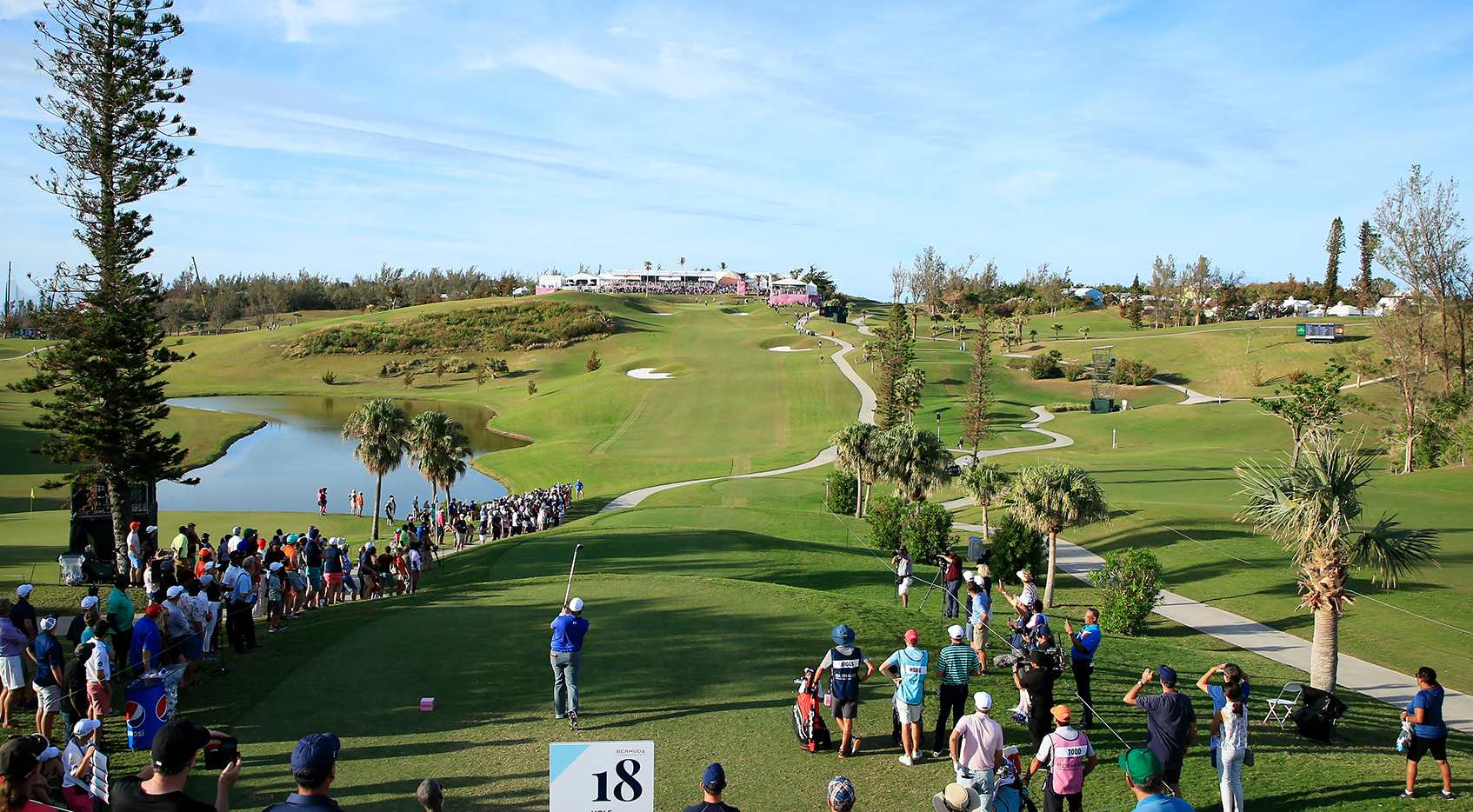 The 18th hole at Port Royal Golf Course, the green beside the ocean with Gibbs Hill Lighthouse beyond, from the 2025 Butterfield Bermuda Championship.